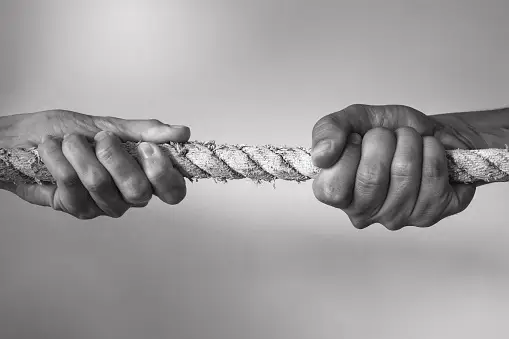 Two people pulling a rope in a tug of war