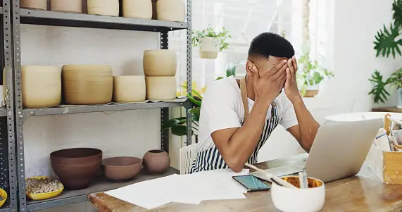 A disappointed service provider holds his head in his hands in despair.